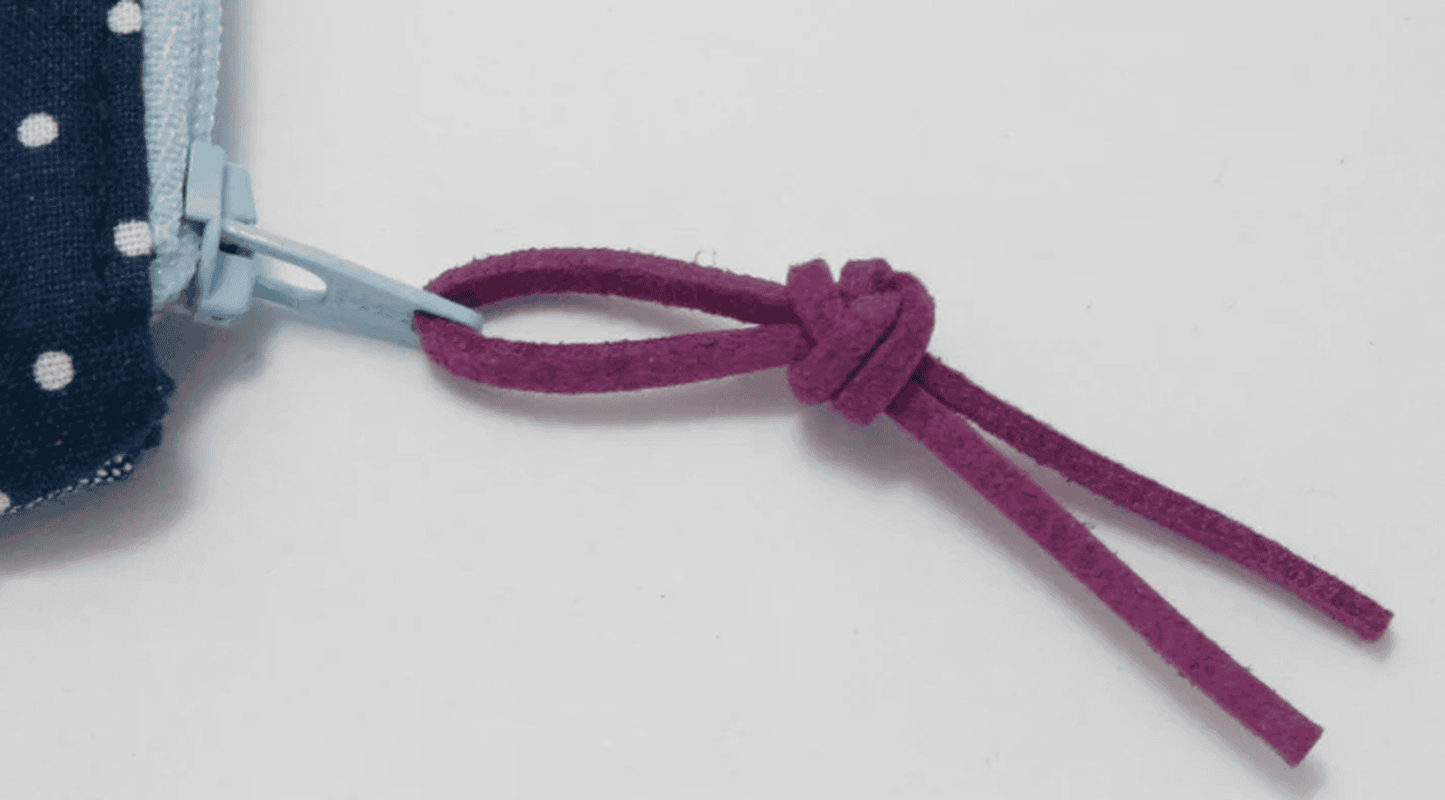 Tie a piece of Bobbin Girl's faux suede cord through the eye of a zipper pull to add interest to your bag making project