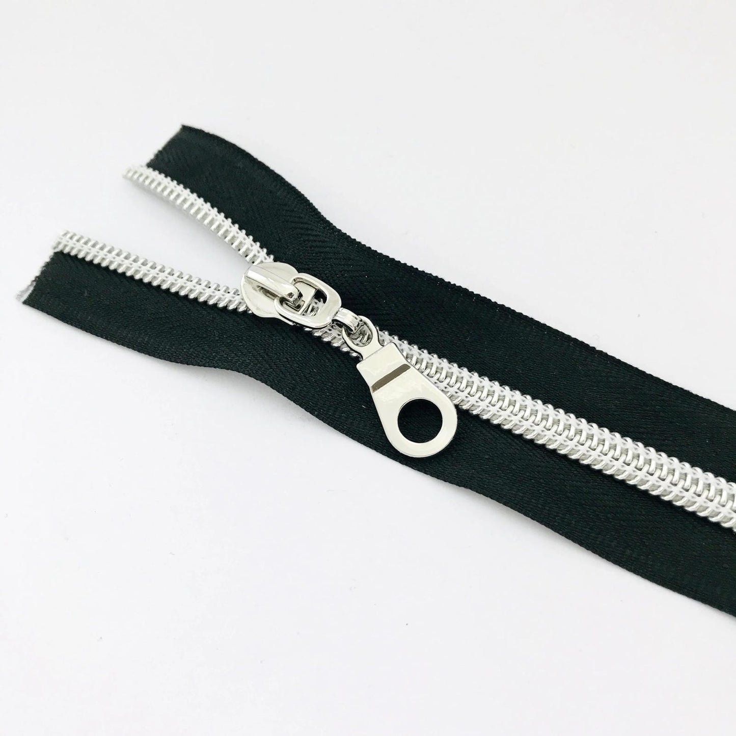 Bobbin Girl's No. 5 Black Zipper Tape is sold by the yard with 3 shiny silver zipper pulls